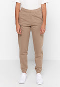 Beige Jogginghose mit elastischem Bund und gerippten Bündchen an den Knöcheln. Mit einem bedruckten Textdetail am linken Bein. Kombiniert mit weißen Sneakers.