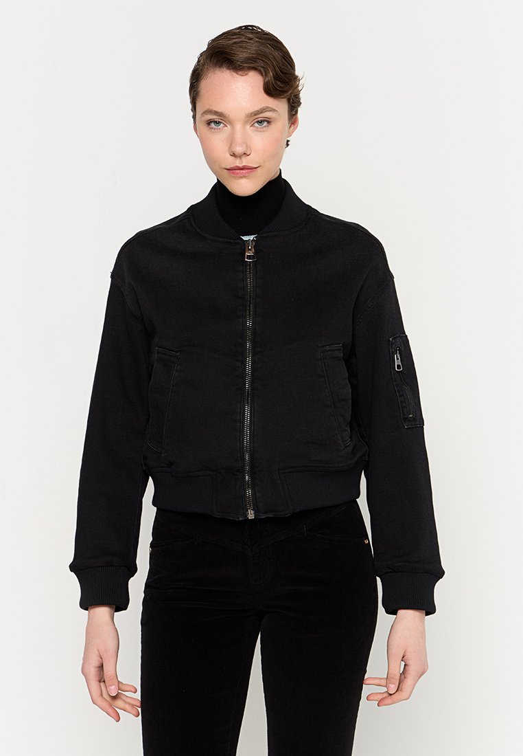 Schwarze Bomberjacke mit Reißverschluss vorne, gerippten Bündchen und Saum. Verfügt über seitliche Taschen und eine Utility-Tasche am linken Ärmel.