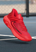 Roter Sportschuh mit einem strukturierten Mesh-Obermaterial, rundem Design und gewellter Sohle. Verfügt über schwarze Akzente und ein auffälliges Schnürsystem.