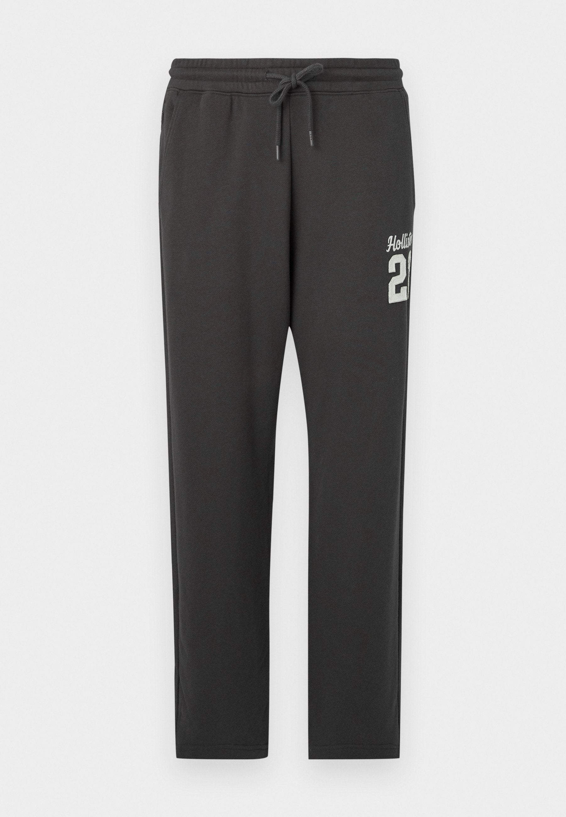 Dunkelgraue Sweatpants mit elastischem Bund und Kordelzug, mit weißem "Hollister 21"-Text auf der oberen linken Oberschenkel.
