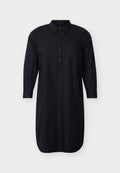 Schwarzes, langärmeliges Hemdkleid mit Kragen, durchgehendem Knopfleistenverschluss, seitlichen Taschen und geknöpften Ärmeln, vor schlichter Hintergrundkulisse präsentiert.