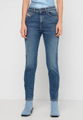 Helle blaue Jeans aus Denim, im Slim-Fit-Schnitt, mit klassischem Fünf-Taschen-Design und subtilen Verbleichungen. Kombiniert mit blauen Stiefeln mit mittelhohem Absatz.
