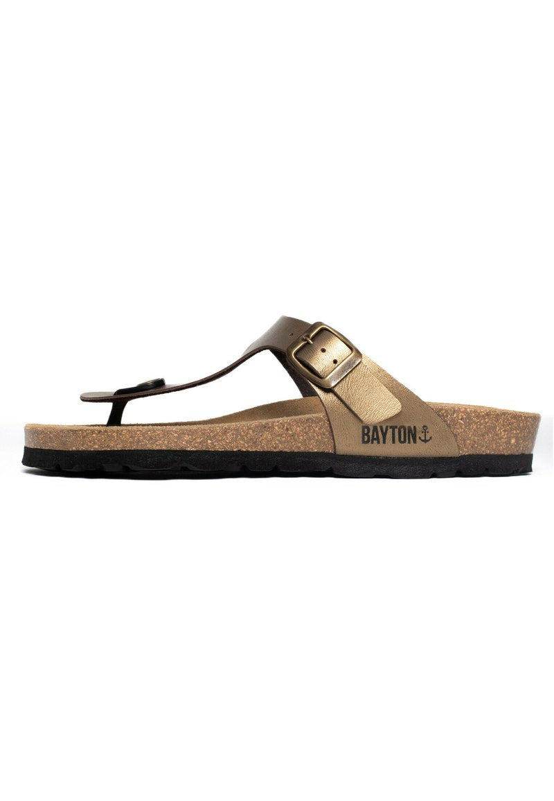 Braune Flip-Flop-Sandale mit einem Korkfußbett, kontrastierender schwarzer Gummisohle und einer dekorativen Metallschnalle an einem synthetischen Riemen.