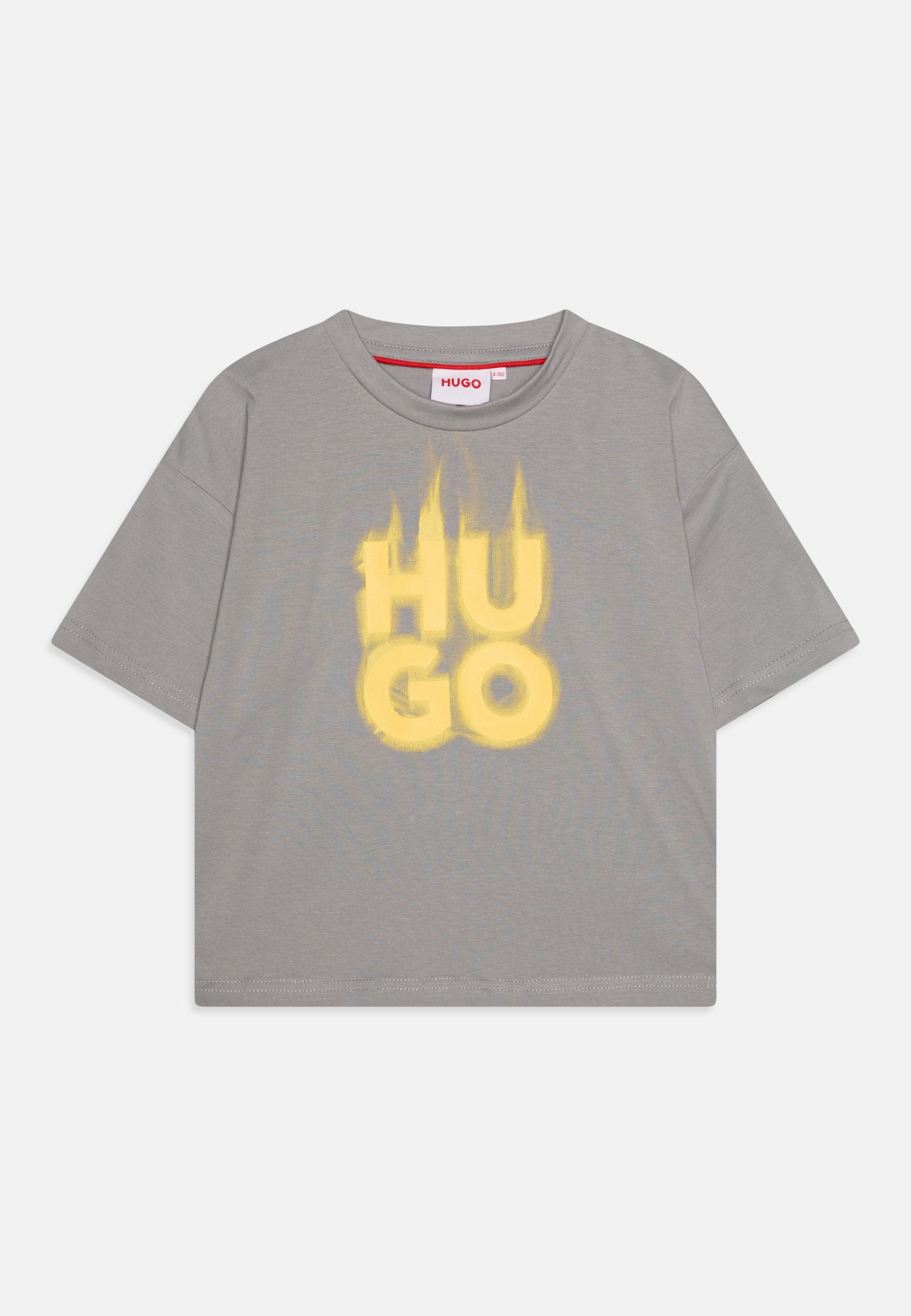 Graues T-Shirt mit kurzen Ärmeln, das einen großen, gelben grafischen Textdruck mit "HU GO" im Used-Look zeigt. Aus Baumwollmaterial mit Rundhalsausschnitt.