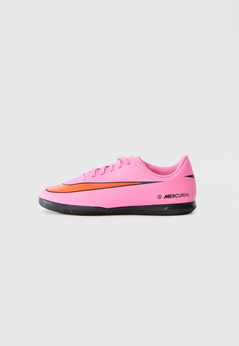 Rosa Nike Mercurial Fußballschuhe mit niedrigem Schnitt, schwarzer Sohle und orangefarbener Swoosh-Loge, Seitenansicht vor einem schlichten, hellen Hintergrund.
