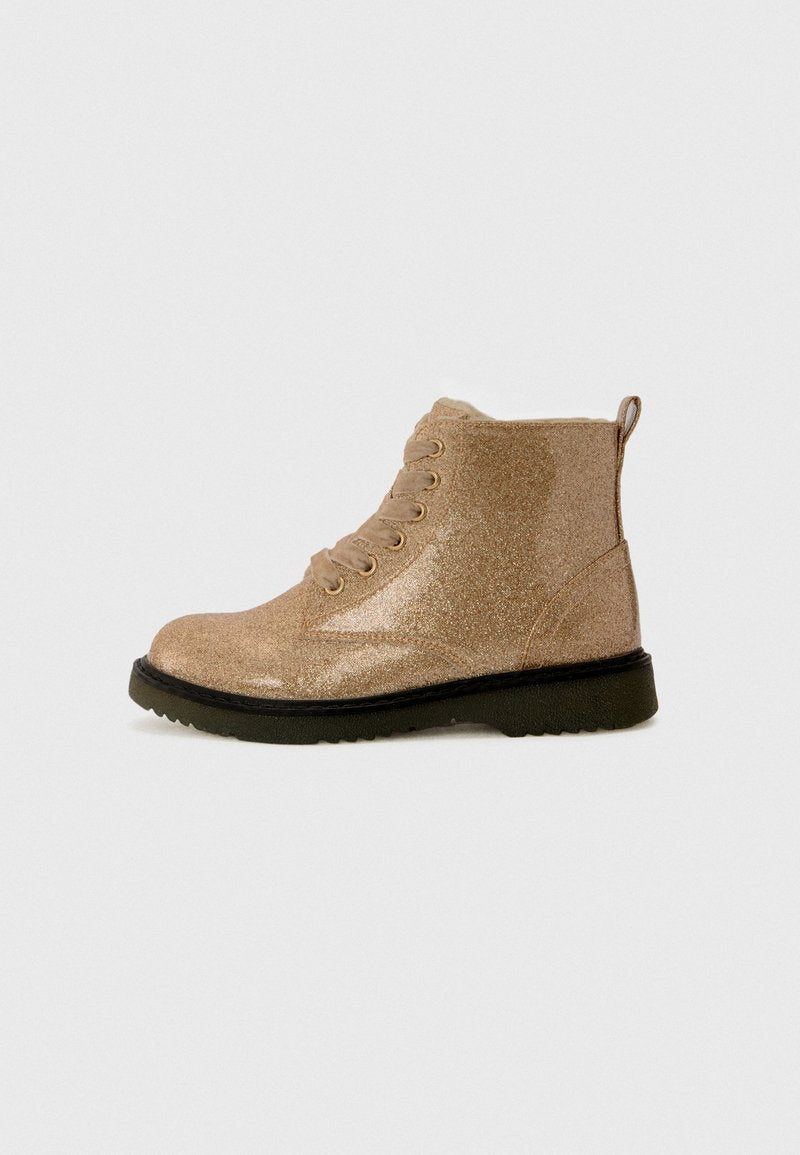 Glitzerndes sandfarbenes Knöchelschuh mit Schnürung, Zuglasche an der Ferse und schwarzem texturiertem Sohlen auf einem schlichten hellen Hintergrund.