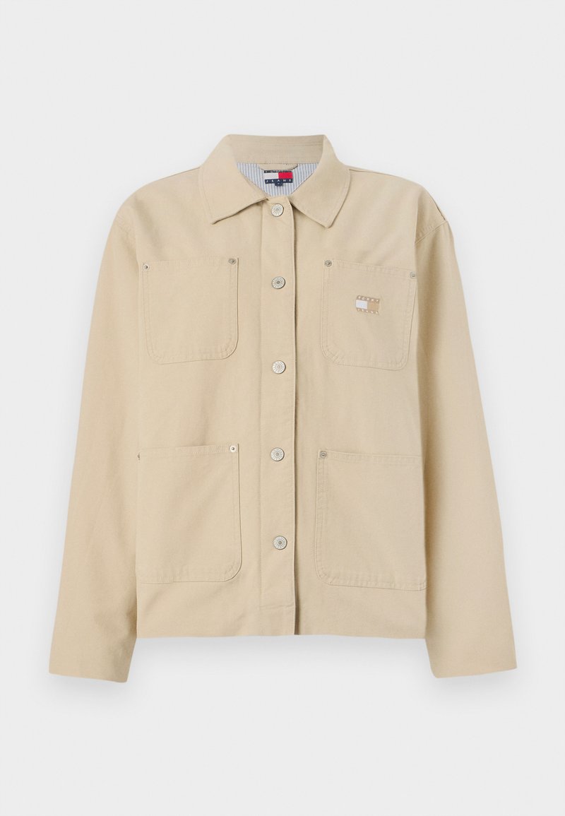 Beige Leinensakko mit spitzem Kragen, vorderer Knopfverschluss, zwei Brusttaschen und einem kleinen Logo-Patch. Weiche Textur und maßgeschneiderte Passform.