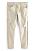 Beige Baumwolljeans im Slim-Fit-Stil, mit zwei vorderen Taschen und sichtbaren Rissen an den Knien. Der Stoff hat eine dezente Textur.