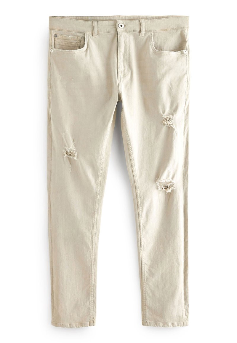 Beige Baumwolljeans im Slim-Fit-Stil, mit zwei vorderen Taschen und sichtbaren Rissen an den Knien. Der Stoff hat eine dezente Textur.