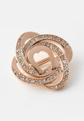 Rosegold-Brosche mit ineinander verschlungenen Schlaufen, verziert mit klaren Strasssteinen, die ein funkelndes Floraldesign auf weißem Hintergrund erzeugen.