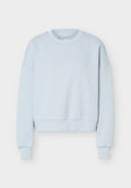 Hellblaues Sweatshirt mit Rundhalsausschnitt, langen Ärmeln und gerippten Bündchen und Saum, flach auf weißem Hintergrund liegend.