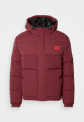 Bordeauxfarbene gepolsterte Winterjacke mit Kapuze, vorderen Taschen mit Knöpfen, elastischen Bündchen und einem kleinen roten HUGO-Logo-Patch auf der Brust.