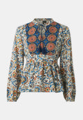 Langärmlige Bluse mit einem komplexen floralen Muster in Blau, Orange und Creme, mit einer gerafften Taille und dekorativen Quasten.