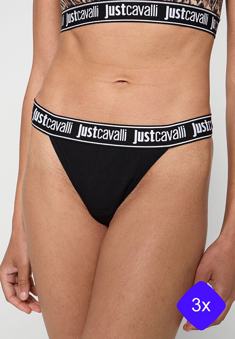 Frau trägt schwarze Unterwäsche mit elastischem Bund der Marke Just Cavalli und passenden Sport-BH, auf Höhe der Körpermitte beschnitten.