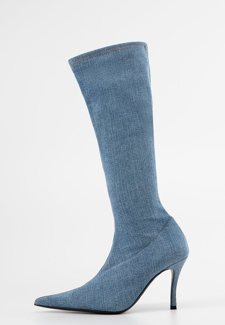 Jeanslangschaftstiefel in Hellblau mit spitz zulaufender Zehe und Stiletto-Absatz. Glatte Textur mit sichtbaren Nähdetails.