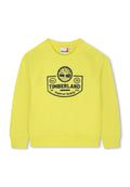 Gelbes Sweatshirt aus strukturiertem Stoff, mit Rippbündchen und -saum. Mit einem auffälligen blauen Logo mit der Aufschrift "TIMBERLAND" und dem Gründungsjahr "73."