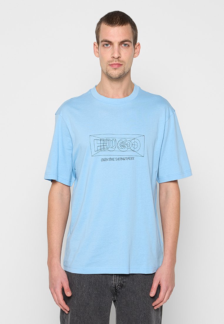 Hellblaues Baumwoll-T-Shirt mit lockerem Schnitt, mit einem schwarz gezeichneten Logo und dem Text "CREATIVE DEPARTMENT" darunter.