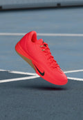 Nike Sportschuh in leuchtendem Pink mit strukturierter Oberfläche, Schnürsenkel-Design und schwarzem Logo. Die Gummisohle bildet einen Kontrast zur lebendigen Farbe.