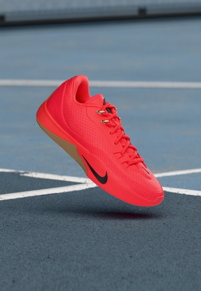 Nike Sportschuh in leuchtendem Pink mit strukturierter Oberfläche, Schnürsenkel-Design und schwarzem Logo. Die Gummisohle bildet einen Kontrast zur lebendigen Farbe.