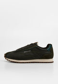 Dunkelgrüne Sneaker aus Leder und Wildleder mit strukturierter Oberfläche, kontrastierender heller Sohle und minimaler Markenkennzeichnung an der Seite.