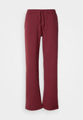 Burgunderfarbene Sweatpants aus weichem Stoff mit einem elastischen Bund und Kordelzug. Sie haben weite Beine und eine glatte Textur über die gesamte Fläche.