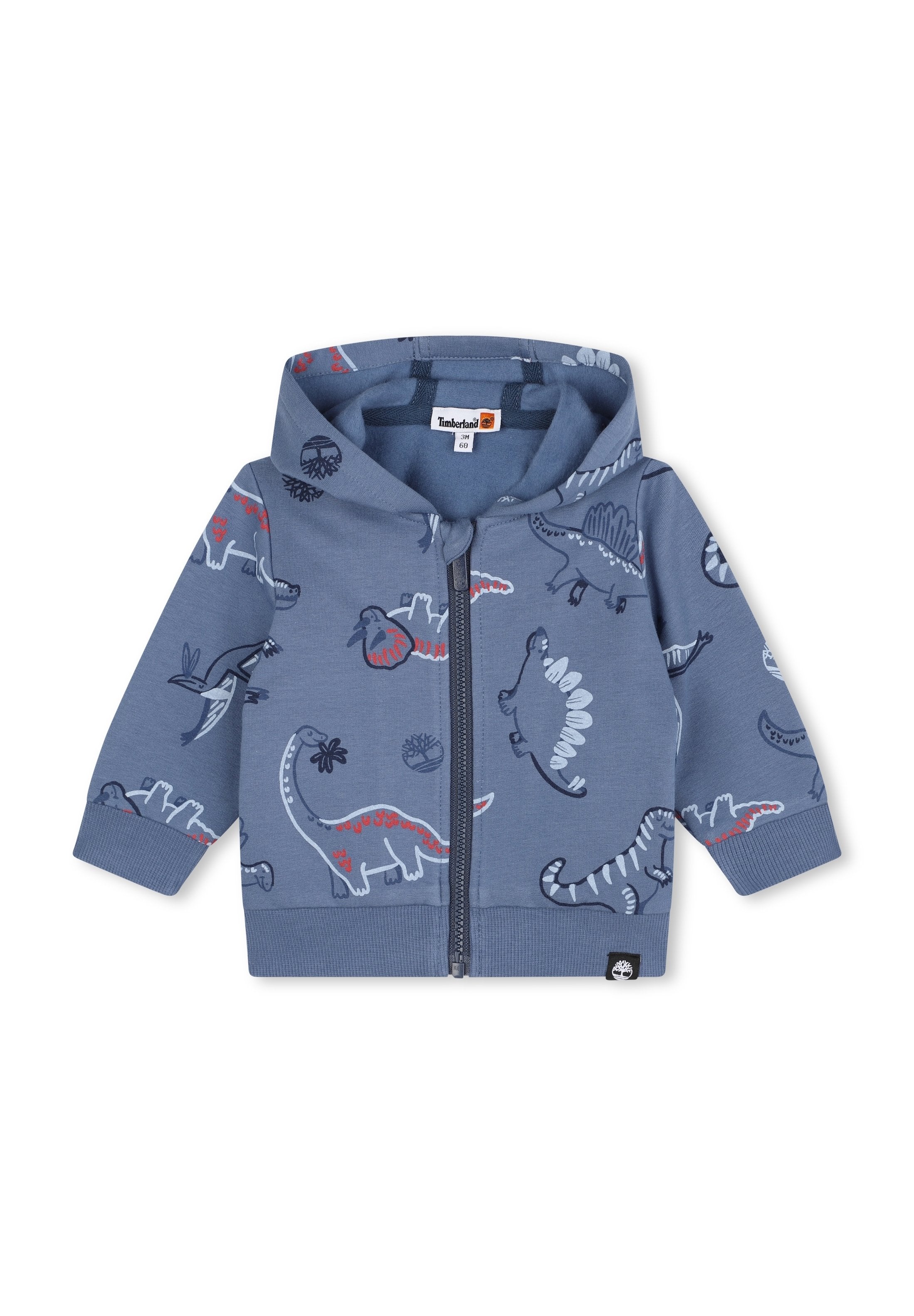 Blaue Kinder Zip-Hoodie mit Kapuze, versehen mit Cartoon-Dinosaurier-Prints in Rot, Weiß und Marineblau. Timberland-Logo am Etikett und Saum.