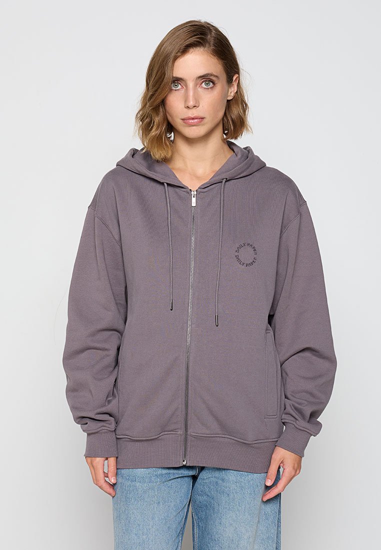 Graue Zip-Hoodie mit lockerer Passform, Kapuze mit Kordelzug, gerippten Bündchen und einem kleinen gedruckten Logo auf der linken Brust. Weicher, strukturierter Stoff.