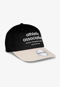 Schwarze Baseballkappe mit einer cremefarbenen Krempe. Sie trägt weißen Text: "Sportverband, der sich immer zum Besseren verändert, niemals zu spät." Rundes Logo-Tag angebracht.