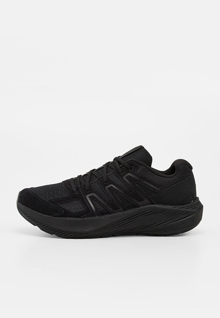Schwarzer Sportschuh mit Mesh- und synthetischem Obermaterial, strukturierter Sohle und Schnürverschluss, Seitenansicht auf weißem Hintergrund.