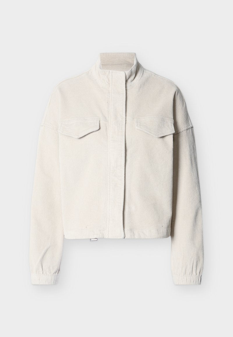 Cremefarbige Cordjacke mit hohem Kragen, vorderen Klappentaschen, elastischen Bündchen und verdecktem Frontverschluss, präsentiert vor einem einfarbigen Hintergrund.
