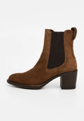 Braune Wildleder-Stiefelette mit runder Zehenpartie, elastischen Seitenpaneelen und einem stabilen Blockabsatz. Glatte Textur mit minimalistischem Design.