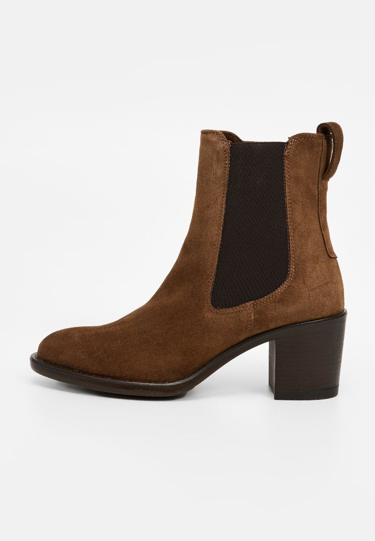 Braune Wildleder-Stiefelette mit runder Zehenpartie, elastischen Seitenpaneelen und einem stabilen Blockabsatz. Glatte Textur mit minimalistischem Design.