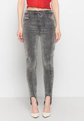 Frau trägt hochtaillierte, acid-wash Skinny Jeans mit Vorderrepuestos und Reißverschlüssen an den Knöcheln, kombiniert mit weißen spitzen Absätzen.