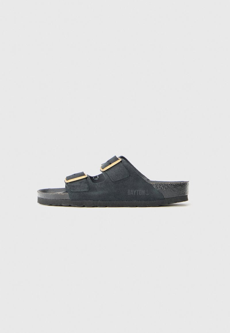 Schwarze Wildleder-Sandalen mit zwei verstellbaren Riemen, goldenen Schnallen und strukturierten Sohlen, die ein dezentes Logo an der Seite aufweisen.