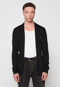 Schwarze Langarm-Cardigan aus geripptem Strick, mit offenem Vorderteil, kombiniert mit einem weißen Tanktop und dunklen Hosen. Minimalistischer Stil.