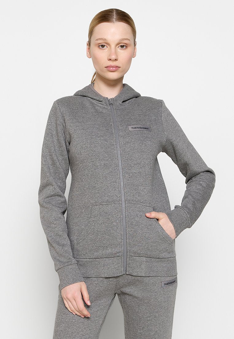 Graue Zip-Hoodie mit Kängurutasche, Kapuze, gerippten Bündchen und einem Logopatch auf der Brust. Hergestellt aus weichem, dehnbarem Material.