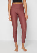 Hoch taillierte Leggings in einem tiefen Burgunderrot, aus glattem, elastischem Stoff mit figurbetontem Design und dezenten Seitentaschen.