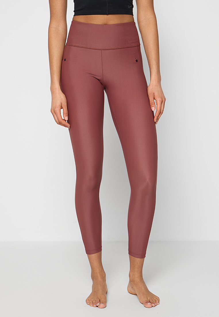 Hoch taillierte Leggings in einem tiefen Burgunderrot, aus glattem, elastischem Stoff mit figurbetontem Design und dezenten Seitentaschen.
