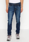 Dunkelblaue Denim-Jeans mit geradem Bein, im klassischen Fünf-Taschen-Stil und mit Kontrastnähten. Getragen mit grauen Sneakers.