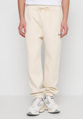 Beige Jogginghose mit elastischem Bund und Kordelzug, mit Bündchen an den Knöcheln, aus weichem Stoff und mit kleinem Markenlogo auf der Vorderseite.