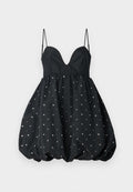 Schwarzes Kleid mit tiefem Ausschnitt, dünnen Trägern und einem Bustierrock. Verziert mit metallischen Pailletten, die gleichmäßig auf dem Stoff verteilt sind.