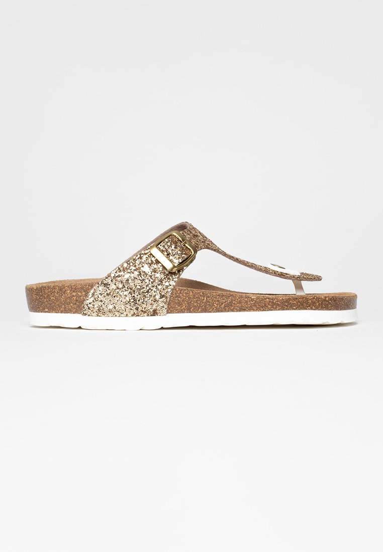 Glitzernde goldene Flip-Flop-Sandale mit einem Korkfußbett, weißer Sohle und einer metallischen Schnallenverzierung am Riemen für einen sicheren Sitz.