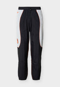 Schwarz-weiße Jogginghose mit orangenen Paspelierungen, elastischem Bund und einem kleinen orangenen Logo am linken Oberschenkel.