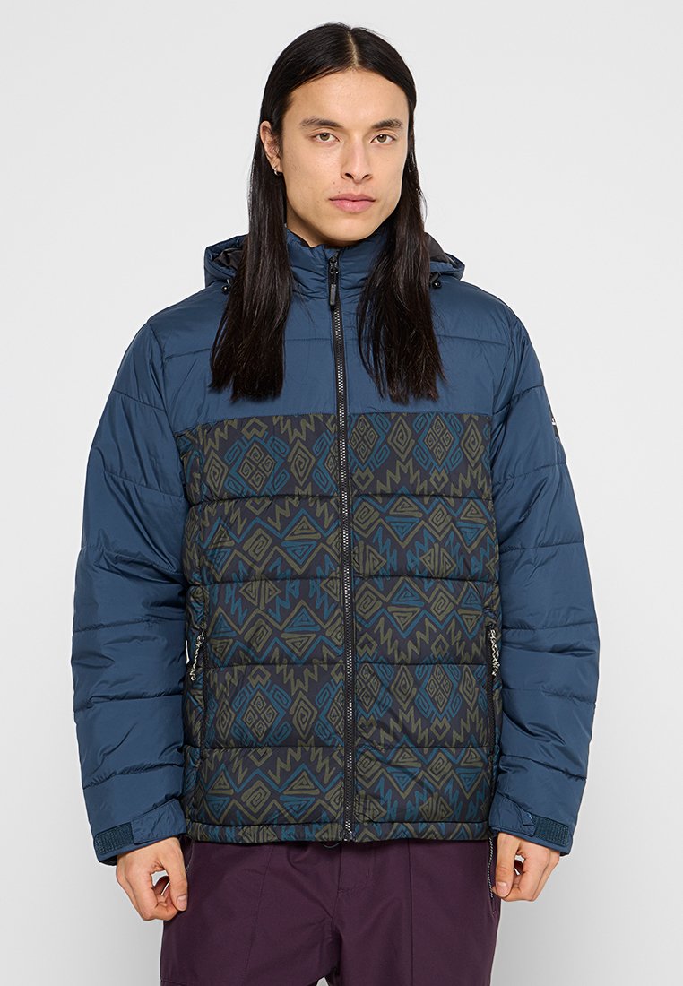 Dunkelblaue gepolsterte Jacke mit einem geometrischen Muster in Grüntönen und Blau im unteren Bereich. Verfügt über einen Reißverschluss und eine Kapuze.