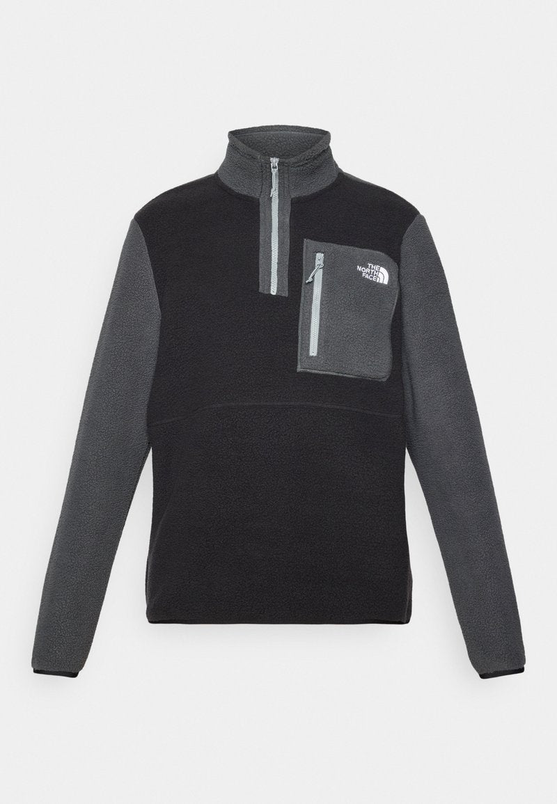 Fleece-Pullover in Schwarz und Grau, Viertel-Reißverschluss-Design, hoher Kragen, Brusttasche mit Reißverschluss, weiche Textur und Logo auf der Tasche.