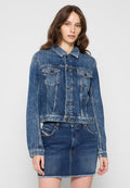 Jeansjacke in verblasstem Blau mit spitzem Kragen, zwei Brusttaschen, Metallknöpfen und einem kurzen Schnitt, kombiniert mit einem passenden Jeansrock.