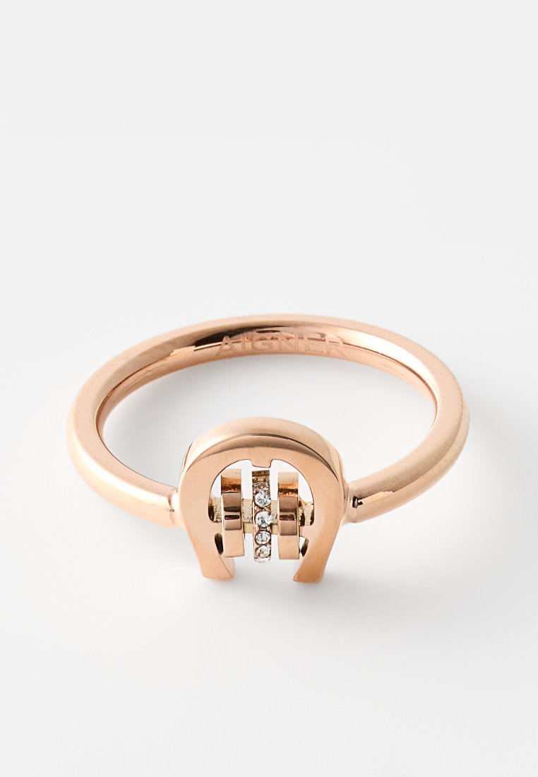 Rosegoldring mit einem Hufeisen-Design und drei kleinen diamantähnlichen Steinen, die in der Mitte eingesetzt sind. Glatte, polierte Oberfläche.