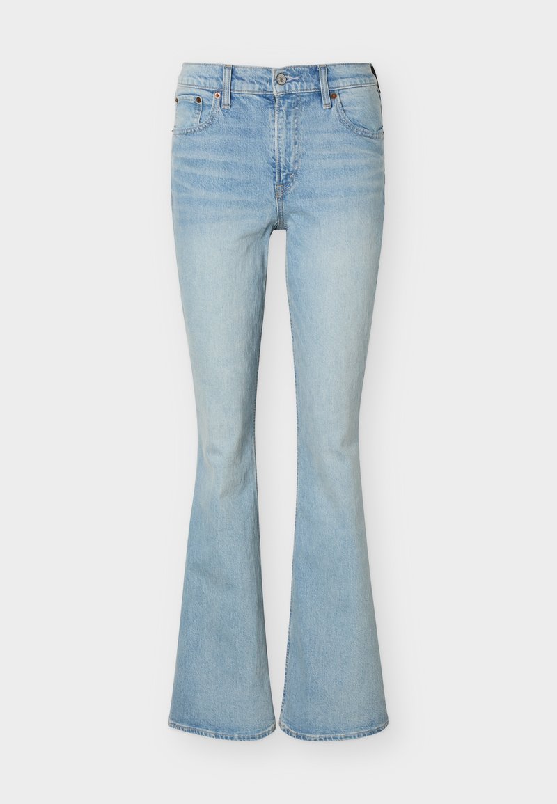 Hellblaue, hoch taillierte Jeans aus Denim mit ausgestelltem Bein, Vorderknopf, Reißverschluss und Fünf-Taschen-Design vor einfachem Hintergrund.