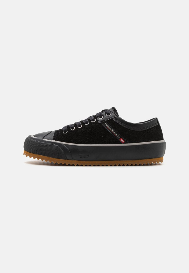 Schwarzer Sneaker mit einer strukturierten Oberseite, Gummikappe und einer Sohle aus Gummi mit einem Zickzackmuster. Schnürdesign mit sichtbaren Ösen.