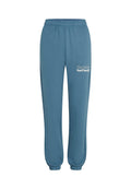Blaue Sweatpants mit elastischem Bund und enganliegenden Knöcheln sowie weißem Text "The Future Surf Society" auf dem oberen linken Bein.